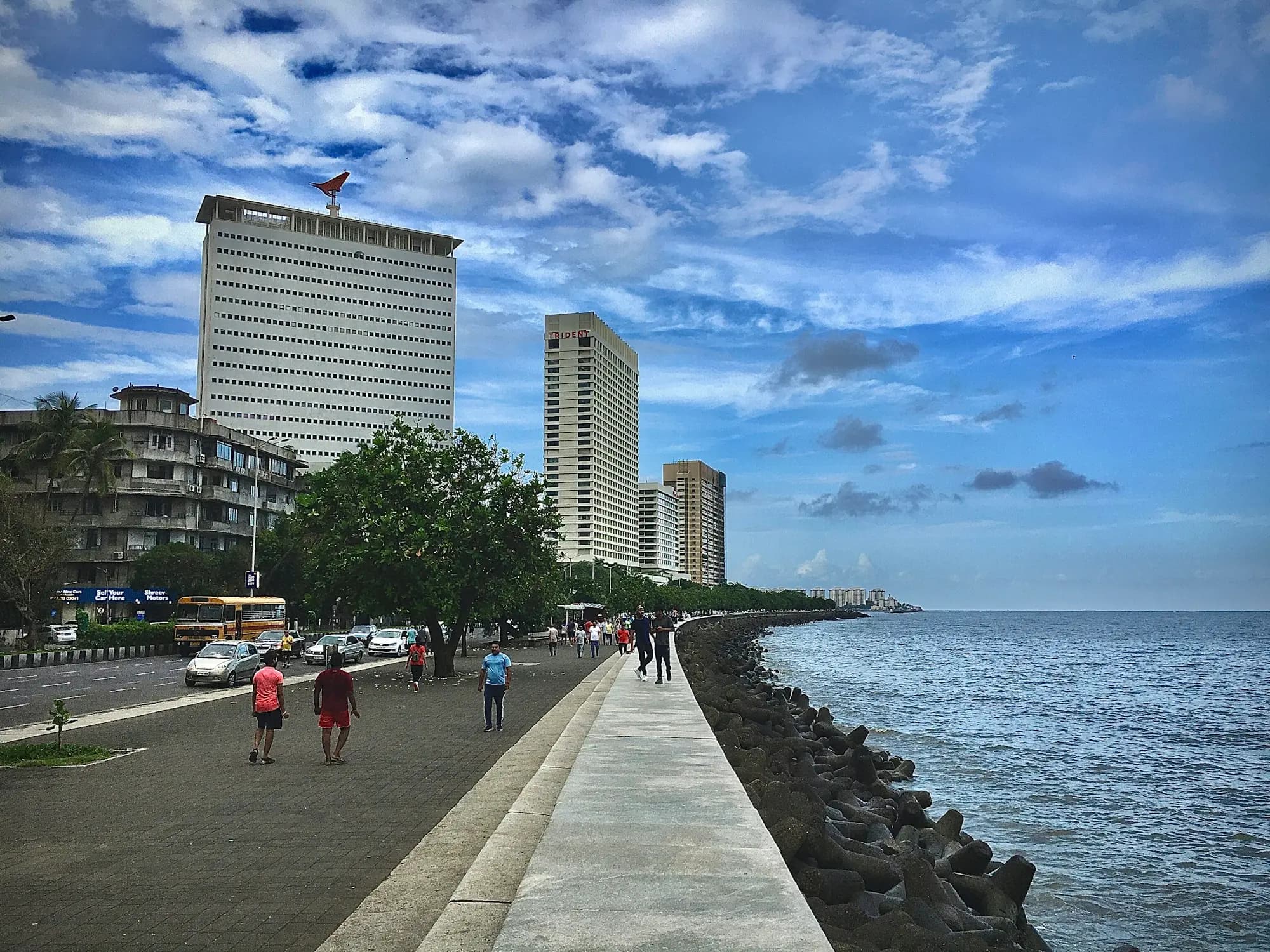 A seafront city road curving along the coast.