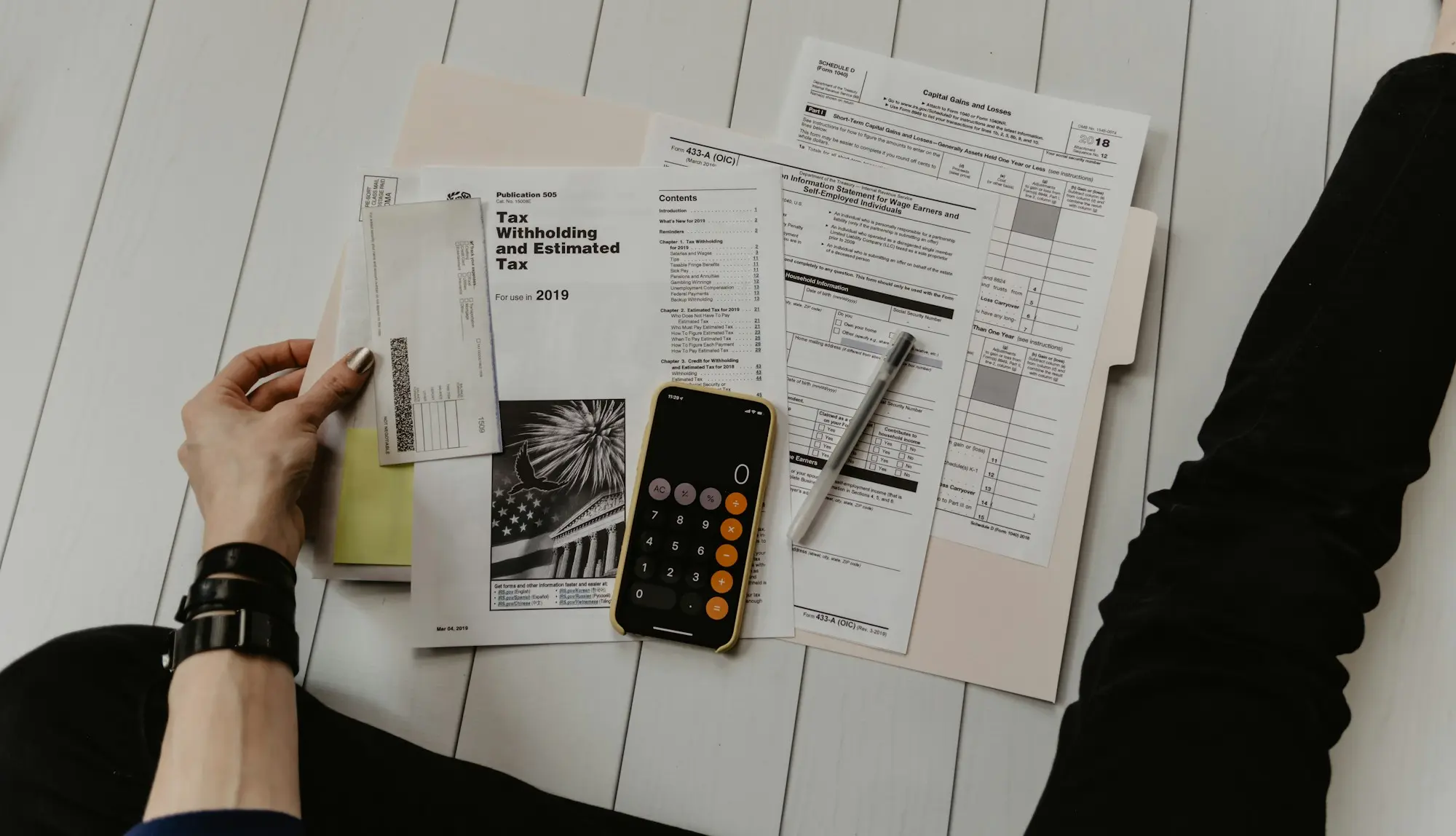 Printed records and a calculator spread across a desk.